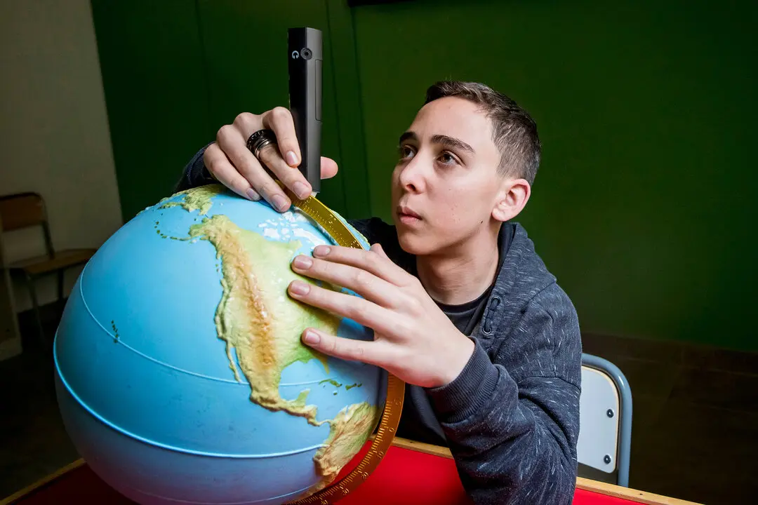 Un alumno ciego con una bola del mundo adaptada / ONCE