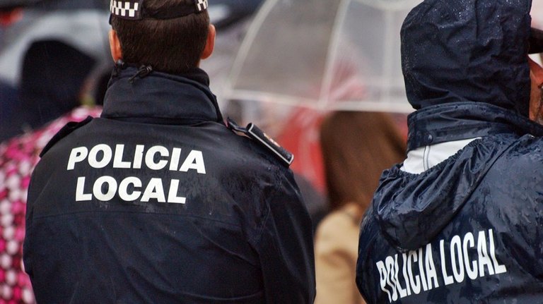 policía local espaldas lluvia