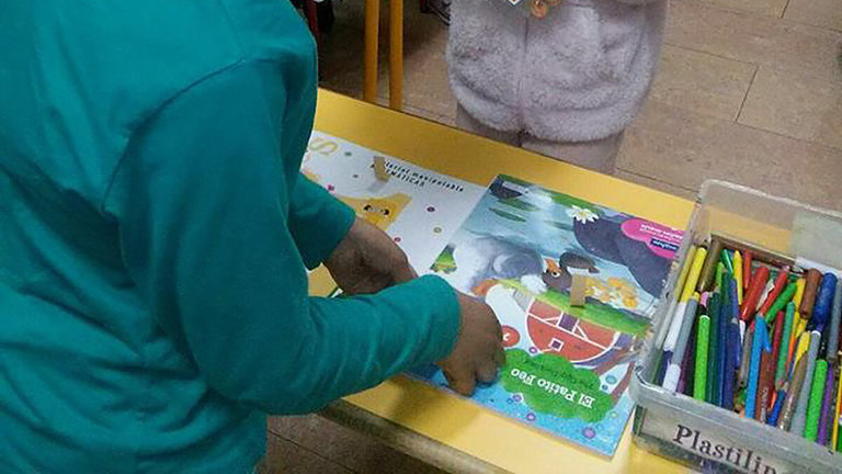Dos niñas juegan con libros en uno de los talleres de Digmun. Foto cedida.