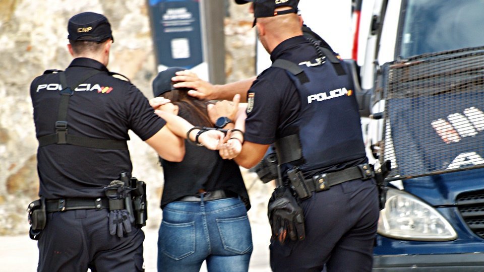 Dos funcionarios del CNP, custodiando a una persona detenida