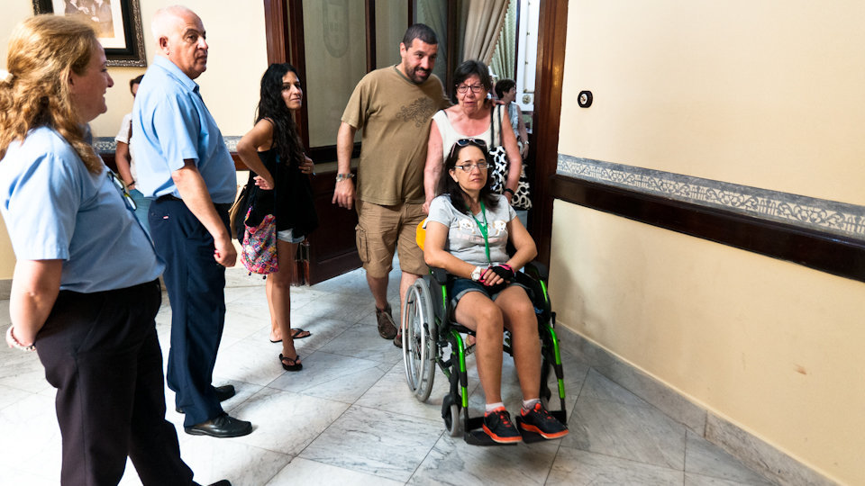 Turistas en silla de ruedas visitan el Palacio Autonómico