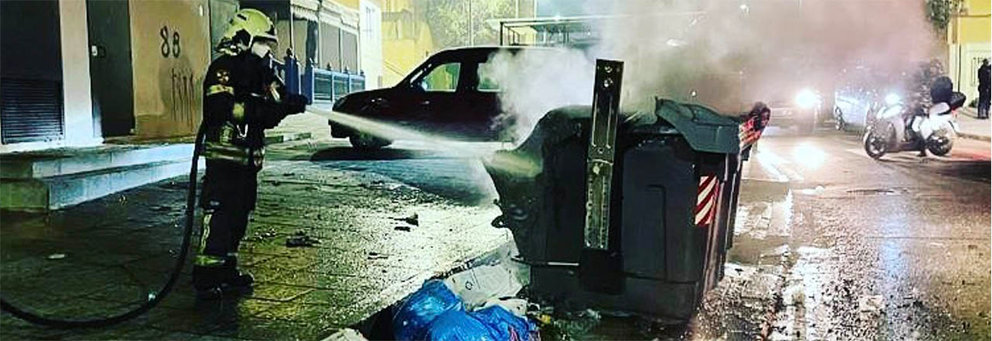 Un bombero apaga el incendio intencionafo de un contenedor de basura. Foto del perfil de Instagram de @frbomberosceuta