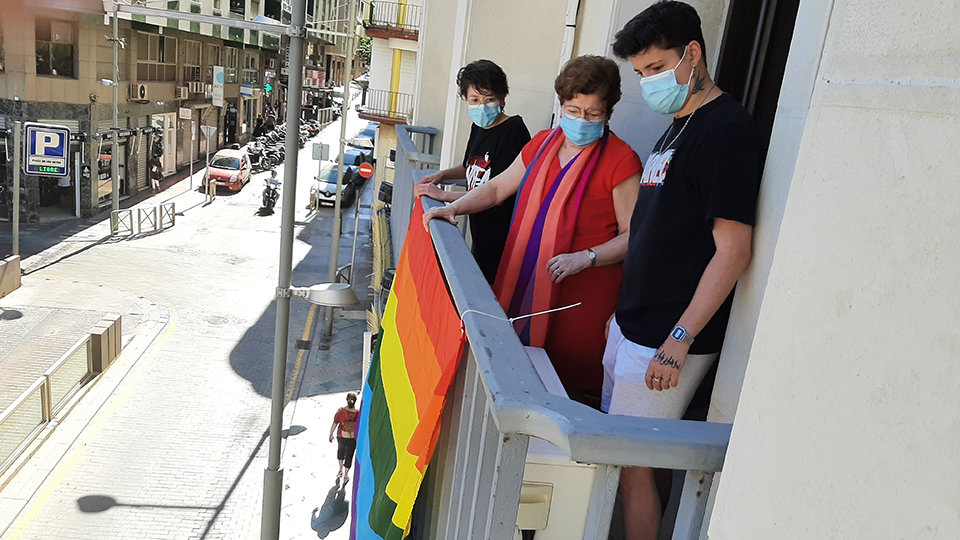 La delegada del Gobierno cuekga la bandera arco iris junto a dos representantes del Consejo de la Juventud