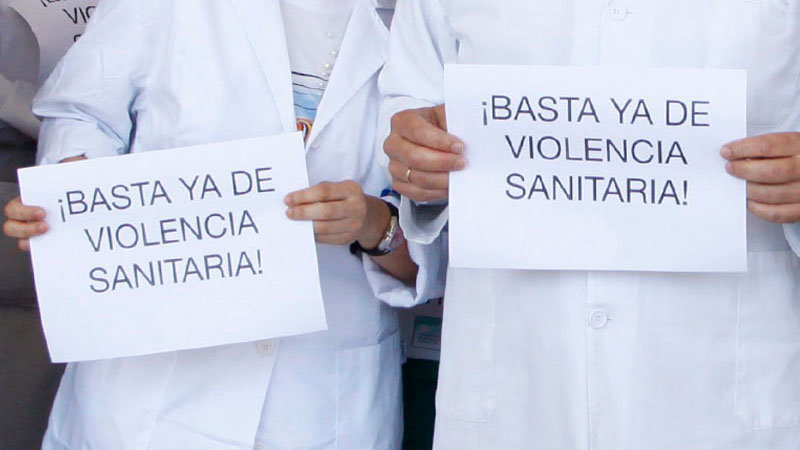 Dos sanitarios, portando proclamas contra la violencia