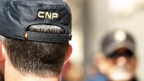 Un polic&iacute;a nacional, de espaldas