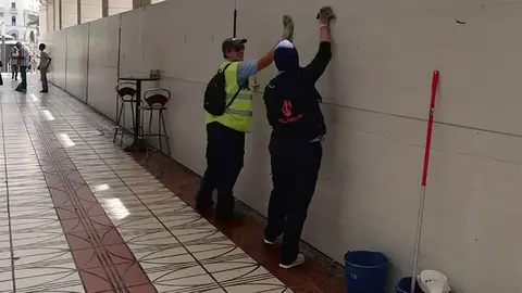 Operarios del Plan de Empleo sacando brillo a la otra valla de Ceuta, la de las obras de la Gran V&iacute;a.