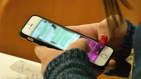 Una mujer, haciendo uso de un tel&eacute;fono m&oacute;vil