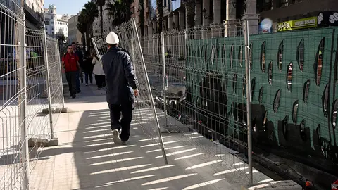 Un operario retira el vallado de obra de Gran V&iacute;a peq