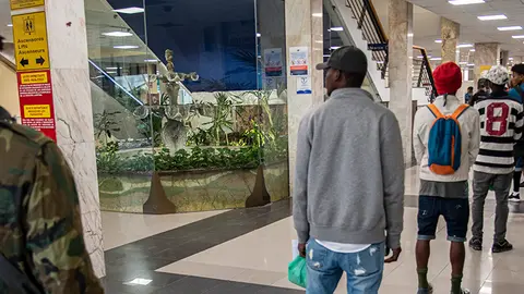 Migrantes esperan en fila para embarcar en el ferry