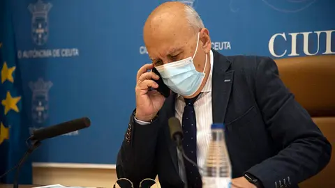 Javier Guerrero habla por tel&eacute;fono con mascarilla poco antes de su comparecencia semanal
