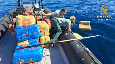 Dos agentes de la Guardia Civil recuperan del mar fardos de hach&iacute;s
