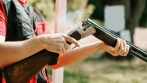 Un hombre, recargando una escopeta de caza