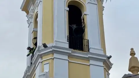 Un bombero, apuntalando una de las campanas de la catedral