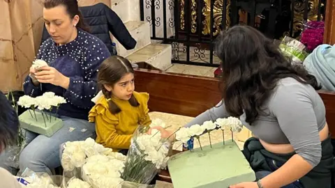 Un grupo de cofrades prepara las flores / Dani Hern&aacute;ndez