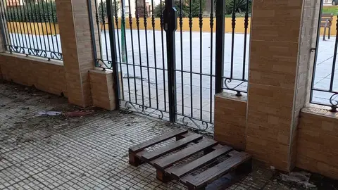 La entrada a la urbanizaci&oacute;n Loma del Pez con el palet que los vecinos utilizan para sortear las inundaciones