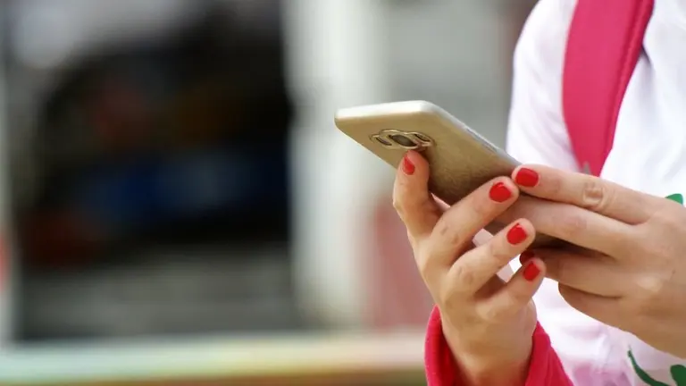 Una mujer, haciendo uso de su tel&eacute;fono m&oacute;vil