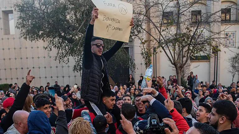 Un manifestante muestra una pancarta con lema %22Fuera Vox, bienvenida Mari Carmen%22