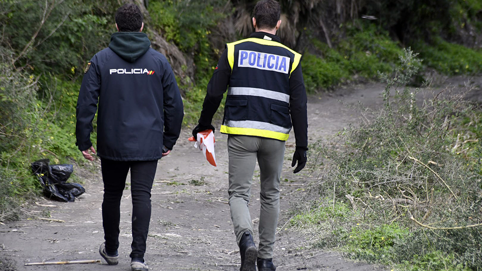 Agentes de Policía con una cinta para señalar una ziona acordonada