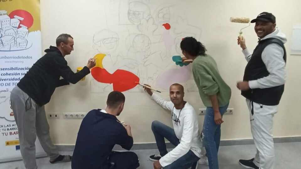 Un grupo de vecinos de Príncipe Alfonso, pintando el nuevo mural del local social de la barriada