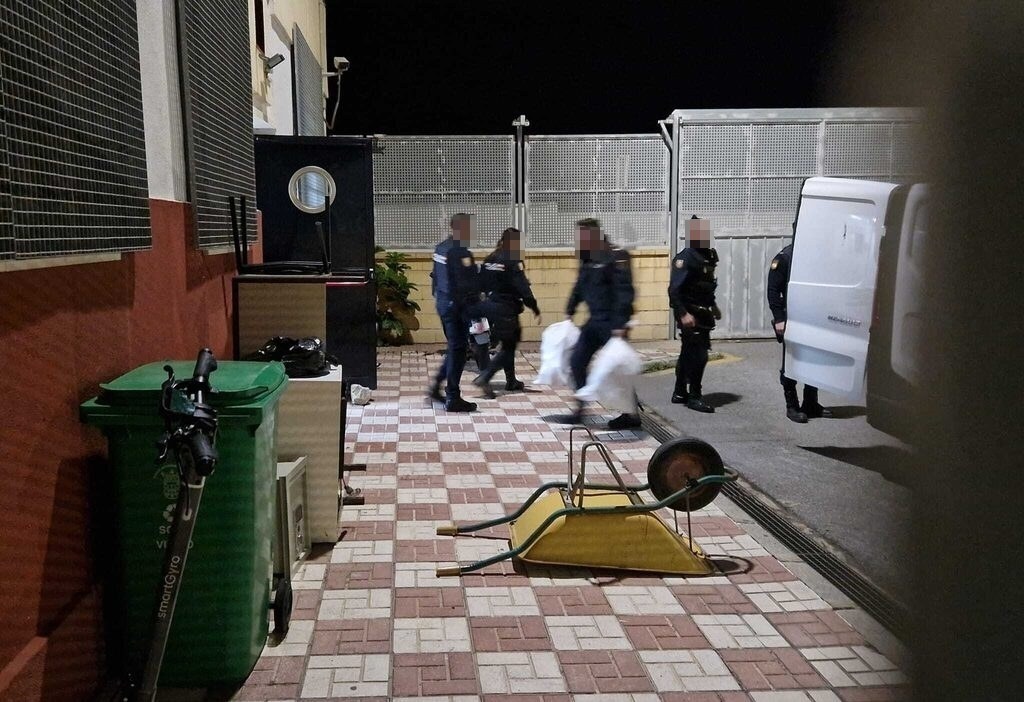 Agentes entrando en la comisaría con material decomisado.